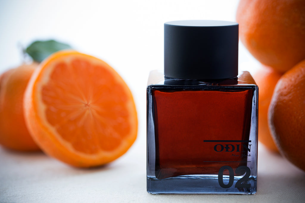 Odin 02 Owari fragrance EDP bottel with orange citrus in background. Slide 1 of 1