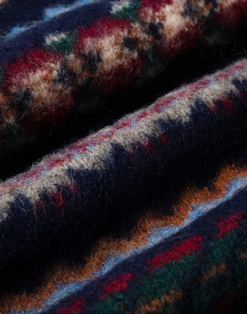 Howlin' Woolen Wonder sweater close-up shot of Fair Isle pattern in red, blue, green, orange, red and light blue. Slide 4 of 4