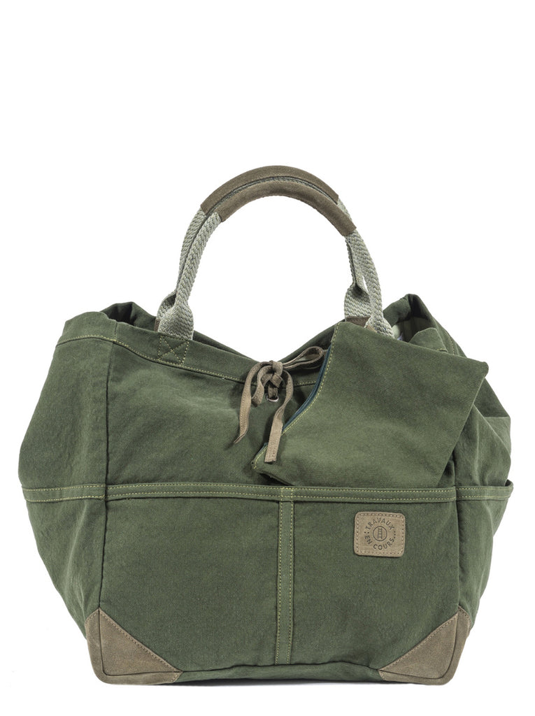 Front view of the green tote bag with two curved handles with leather trim.  Khaki green leather tie in the center of bag with khaki green logo patch on center right of bag.  Rectangular zip pocket is pulled out from the interior to show independent functionality.  Slide 1 of 4