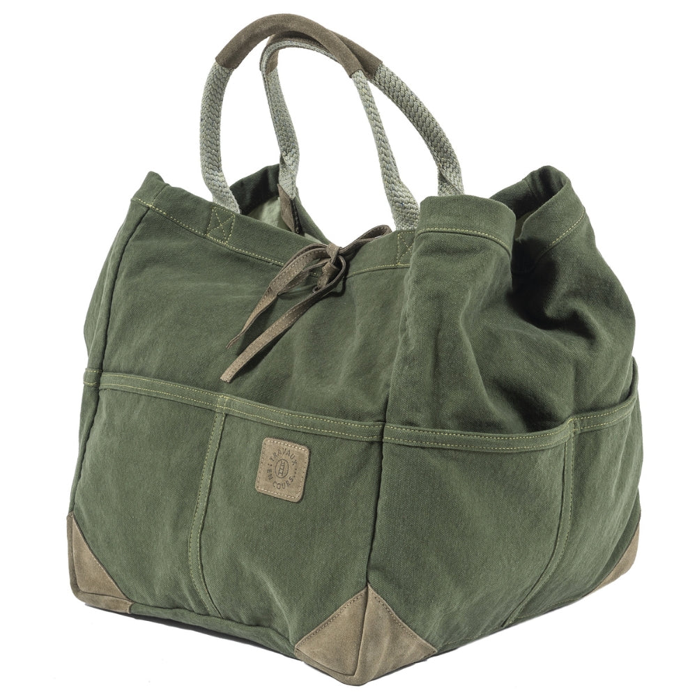 3/4 angle view of the green large tote bag with two curved handles with leather trim.  Khaki green leather tie in the center of bag with khaki green logo patch on center right of bag.  Slide 3 of 4