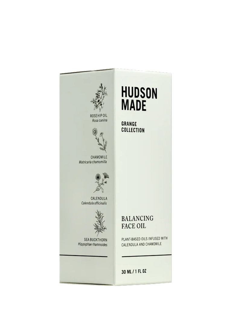 3/4 turn of the Hudson Made Balancing face oil box with black print.  Side show illustrations of the key ingredients "Rosehip oil, chamomile, calendula and sea buckthorn".  Slide 2 of 2 