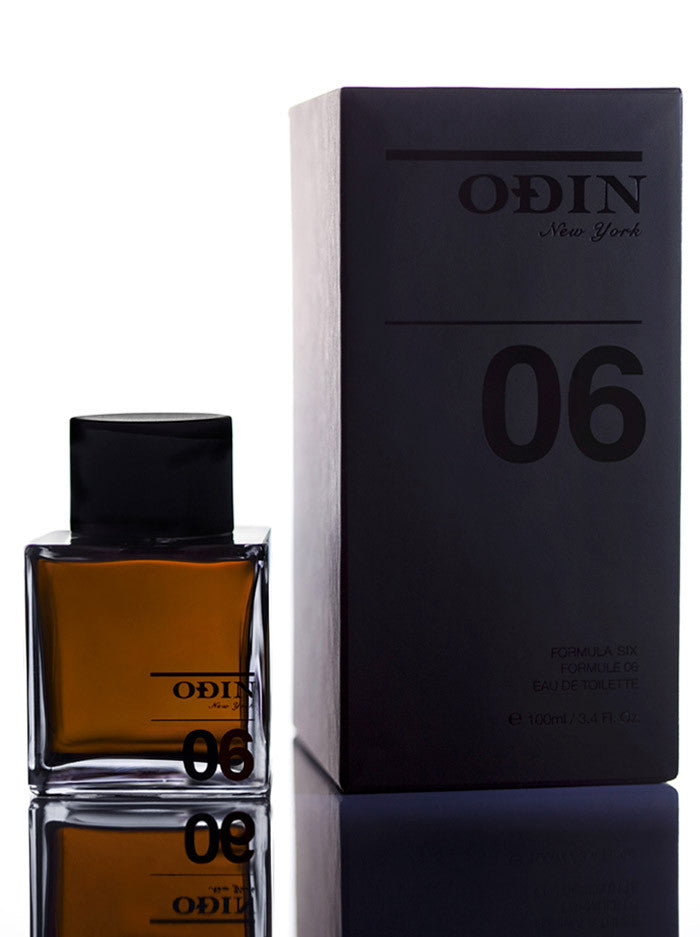 06 Amanu Edp photograph shows the black capped glass bottle with fragrance and black box 