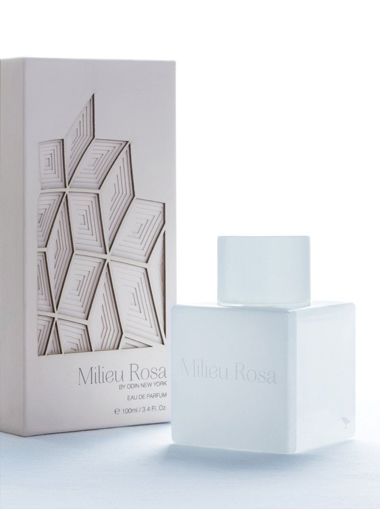 Milieu Rosa EDP in a white bottle with white cap.  Milieu Rosa is printed on the bottle.  Light pink Milieu Rosabox with pattern resembling leaves pattern cut to show depth.