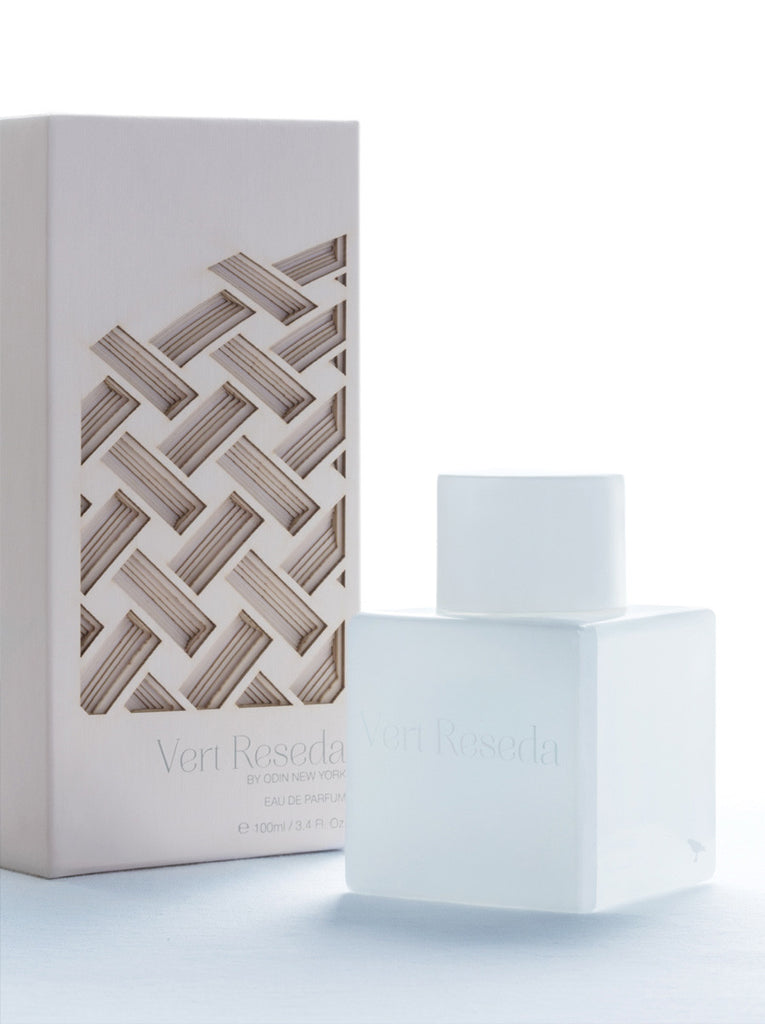 Vert Reseda EDP in a white bottle with white cap.  Vert Reseda is printed on the bottle.  Light pink Vert Reseda box with circle like pattern cut to show depth.